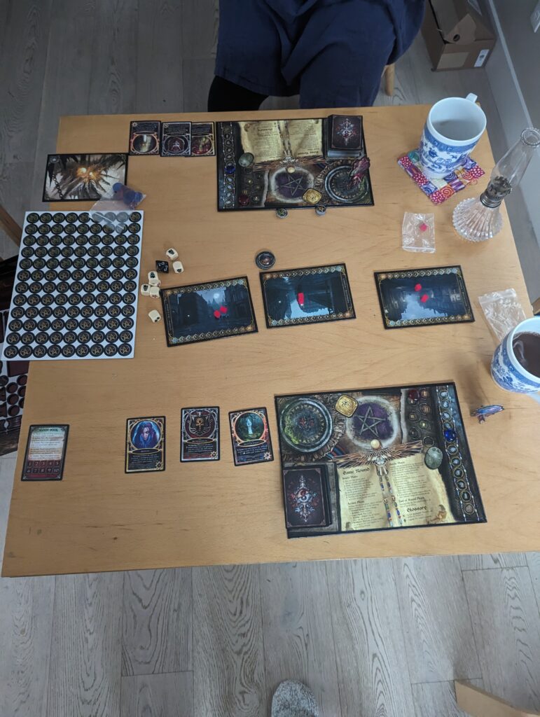 Image of setting up Sorcerer. Each player has a player board and three permanent cards. Three cards representing battlefields are between the players.