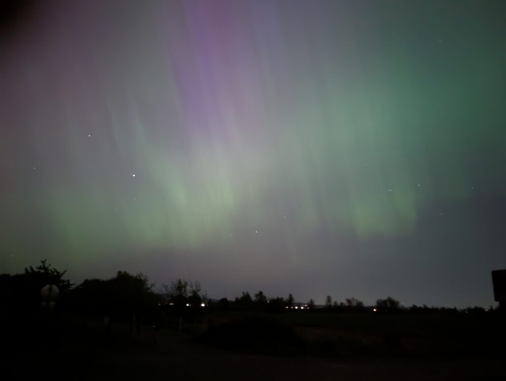 Night sky with green and purple lights in the sky.